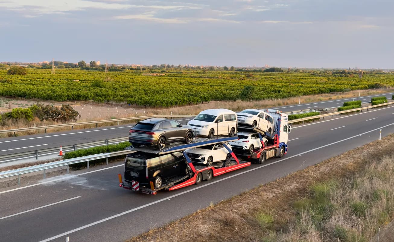 Car transporter truck transporting vehicles on highway - Alaska auto transport