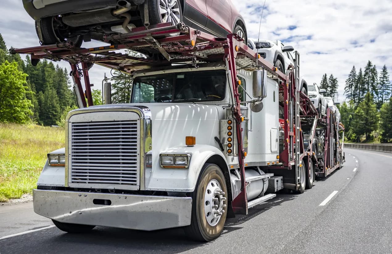 Car transporter truck transporting vehicles on highway - Georgia auto transport