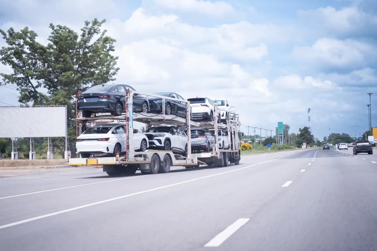 Car transporter truck transporting vehicles on highway - Illinois auto transport