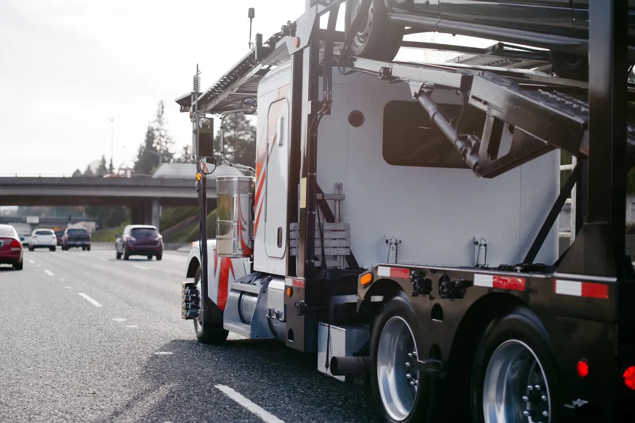 Car transporter truck transporting vehicles on highway - Maine auto transport