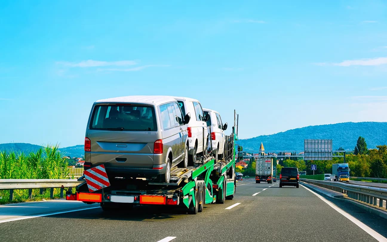 Car transporter truck transporting vehicles on highway - Massachusetts auto transport