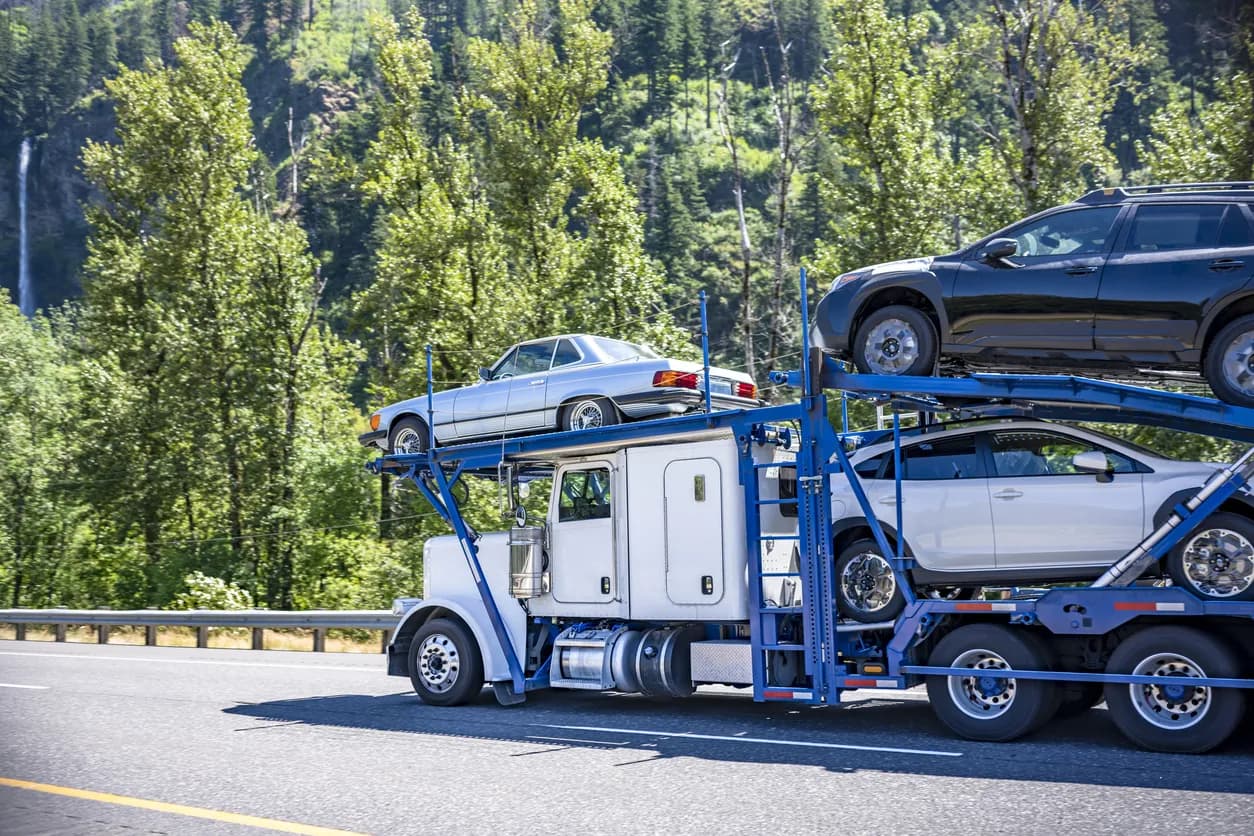 Car transporter truck transporting vehicles on highway - Washington auto transport