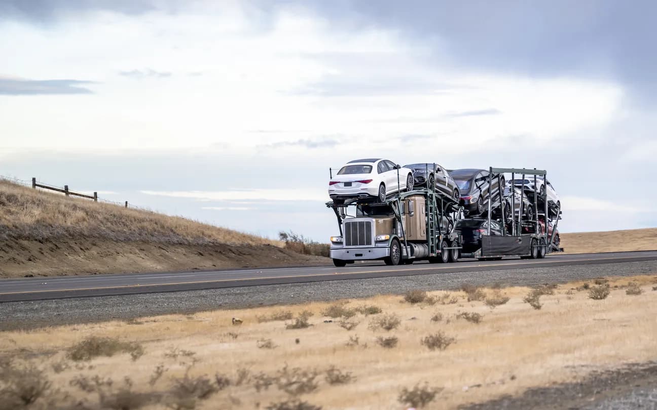 Car transporter truck transporting vehicles on highway - California auto transport
